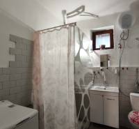 Badezimmer in einem Einfamilienhaus mit Badewanne, Toilette und Waschmaschine.
