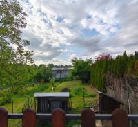 Der Garten des Einfamilienhauses in der Partizánska-Straße in Malý Krtíš mit Grünflächen und einem Holzzaun.
