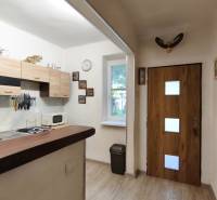 Küche in einem Einfamilienhaus mit Schränken, Herd, Spüle und Fenster.