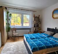 Schlafzimmer im Einfamilienhaus mit Bett, Schrank, Teppich und Wanddekorationen.
