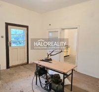 Ein Zimmer in einem Einfamilienhaus mit Holzboden, Dekor, Tisch und Geräten.
