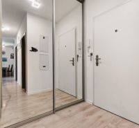 Eingangsbereich einer 3-Zimmer-Wohnung in der Vukovarská-Straße mit weißen Wänden und einem Spiegel.