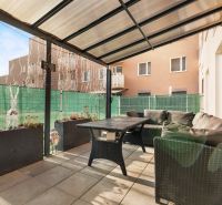 Terrasse mit Sofa und Tisch, umgeben von Pflanzen und einem Zaun an der Vukovarská-Straße.