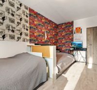 Ein Zimmer mit Graffiti-Tapeten, zwei Betten, einem Tisch und einem Fernseher, ideal für Kinder.