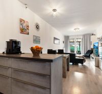 Wohnzimmer mit Sofa, Balkon und Küchenzeile in einer 3-Zimmer-Wohnung in der Vukovarská-Straße.