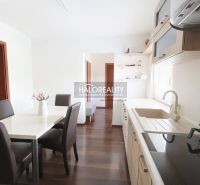 Kücheninterieur eines Einfamilienhauses mit Esstisch und Boden in Holzdekor.