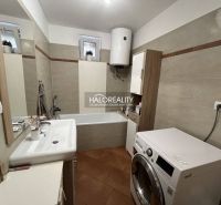 Badezimmer in einem Einfamilienhaus mit Dusche, Waschmaschine und Waschbecken.