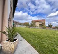 Der Garten des Einfamilienhauses in der Lipová-Straße in Dubová mit Rasen und gepflastertem Gehweg.