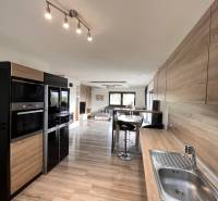 Küche in einem Einfamilienhaus mit Holzboden und praktischer Sitzgelegenheit.