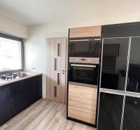 Küche in einem Einfamilienhaus mit einem Gasherd und Geräten, Boden mit Holzdekor.