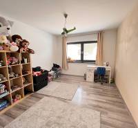 Kinderzimmer mit Spielzeug, Tisch und Holzboden in einem Einfamilienhaus.