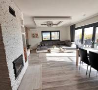 Innenraum eines Einfamilienhauses mit Sofa, Kamin und Holzboden.