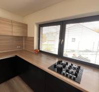 Küche mit Holzdekor und Theke in einem Einfamilienhaus, mit Fenster und Gasherd.