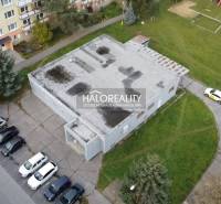 In Rimavská Sobota gibt es Geschäftsräume, die von Plattenbauten und Parkplätzen umgeben sind.