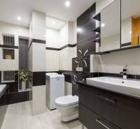 Badezimmer in einer 2-Zimmer-Wohnung mit Dusche, Waschmaschine und Waschbecken.