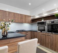 Küche in einer 2-Zimmer-Wohnung, Holzdekor, weiße Fliesen, eingebaute Geräte.