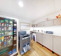 Büros mit einem Snackautomaten, einem Drucker und Schränken, Boden mit Holzdekor.