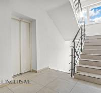 Treppe mit hellem Belag und Aufzug in einer 2-Zimmer-Wohnung.