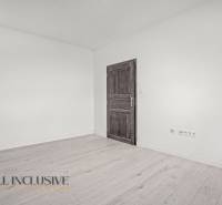 Innenraum einer 2-Zimmer-Wohnung mit weißen Wänden und einem Boden in Holzoptik.