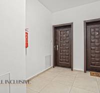 Ein Flur mit zwei Türen und einem Feuerlöscher in einer Zweizimmerwohnung.