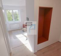 Der Flur in einer 2-Zimmer-Wohnung mit einem Holzboden und Blick in den Raum.