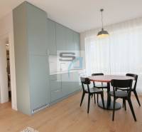 Essbereich mit Tisch und Stühlen, Einbauschränken und einem Boden mit Holzdekor.