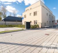 Fassade des Gebäudes in der Železničná-Straße in Bratislava - Vrakuňa, mit Parkplätzen und Grünflächen.