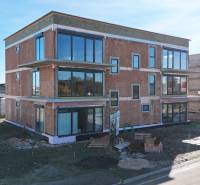 Neubau in der Dúhová-Straße in Slovenský Grob mit verglasten Wänden und Parkplatz.