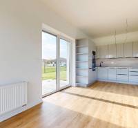 Küche und Wohnbereich in einer 3-Zimmer-Wohnung mit großen Fenstern und Blick ins Grüne.