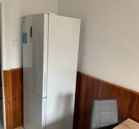 Küche in einer 2-Zimmer-Wohnung mit Kühlschrank, geflieste Wände, Keramikboden.