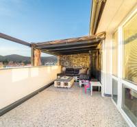 Terrasse mit Sitzgelegenheit, Blick auf Dächer und Hügel in einer 2-Zimmer-Wohnung in der Vajanského-Straße in Modra.