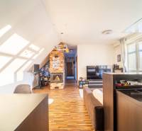 Wohnzimmer in einer 2-Zimmer-Wohnung mit Holzboden und gemauertem Kamin.