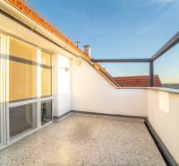 Sonnenterrasse bei einer 2-Zimmer-Wohnung mit Blick auf Dächer und Himmel.