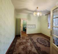 Ein Zimmer in einem Einfamilienhaus mit Teppichboden, grünen Wänden und dekorativer Beleuchtung.