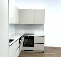 Küche in einer 4-Zimmer-Wohnung mit Holzboden und weißen Schränken.