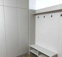 Einbauschrank mit Bank und Haken in einer 4-Zimmer-Wohnung, Boden mit Holzdekor.