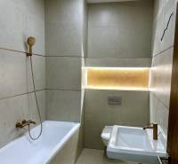 Badezimmer mit Badewanne, Duschkopf, WC und Beleuchtung in einer 4-Zimmer-Wohnung.