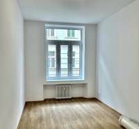 Ein Zimmer mit hellen Wänden und einem Boden in Holzoptik in einer 4-Zimmer-Wohnung.