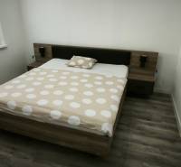 Schlafzimmer mit Doppelbett und Holzboden in einer 3-Zimmer-Wohnung.