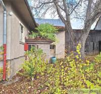 Im Hof eines Einfamilienhauses in Liptovské Beharovce sind Bäume und Holzbauten zu sehen.