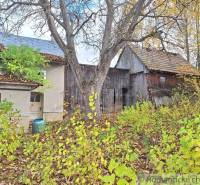 Ein Einfamilienhaus in Liptovské Beharovce, umgeben von herbstlicher Natur, Holzbauten, Bäumen.