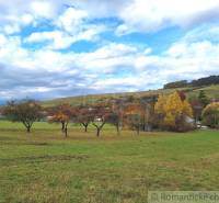 Bunte Herbstlandschaft bei einem Einfamilienhaus in Liptovské Beharovce mit Obstbäumen.