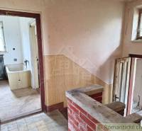 Innenraum eines Einfamilienhauses mit Verkleidung, alter Badewanne und Boden mit Holzdekor.