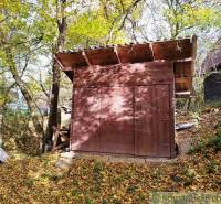 Eine kleine Holzhütte im Wald bei Dudince, umgeben von Herbstblättern.