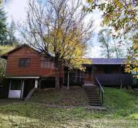 Ein Ferienhaus in Dudince, umgeben von Bäumen und üppigem Grün, ideal zum Entspannen.