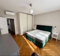 Schlafzimmer mit Bett, Schrank und Boden in Holzoptik in einer 3-Zimmer-Wohnung.