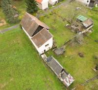 Ein Einfamilienhaus in Sklené in Sklené, umgeben von einem Garten, mit Nebengebäuden und Bäumen.