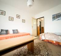 Wohnzimmer in einem Einfamilienhaus mit Teppich und Zeichnungen an der Wand.