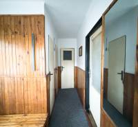 Eingangsflur in einem Einfamilienhaus mit Holzverkleidung und einem Spiegel an der Wand.