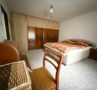 Schlafzimmer in einem Einfamilienhaus mit Teppich, Bett und Schrank.